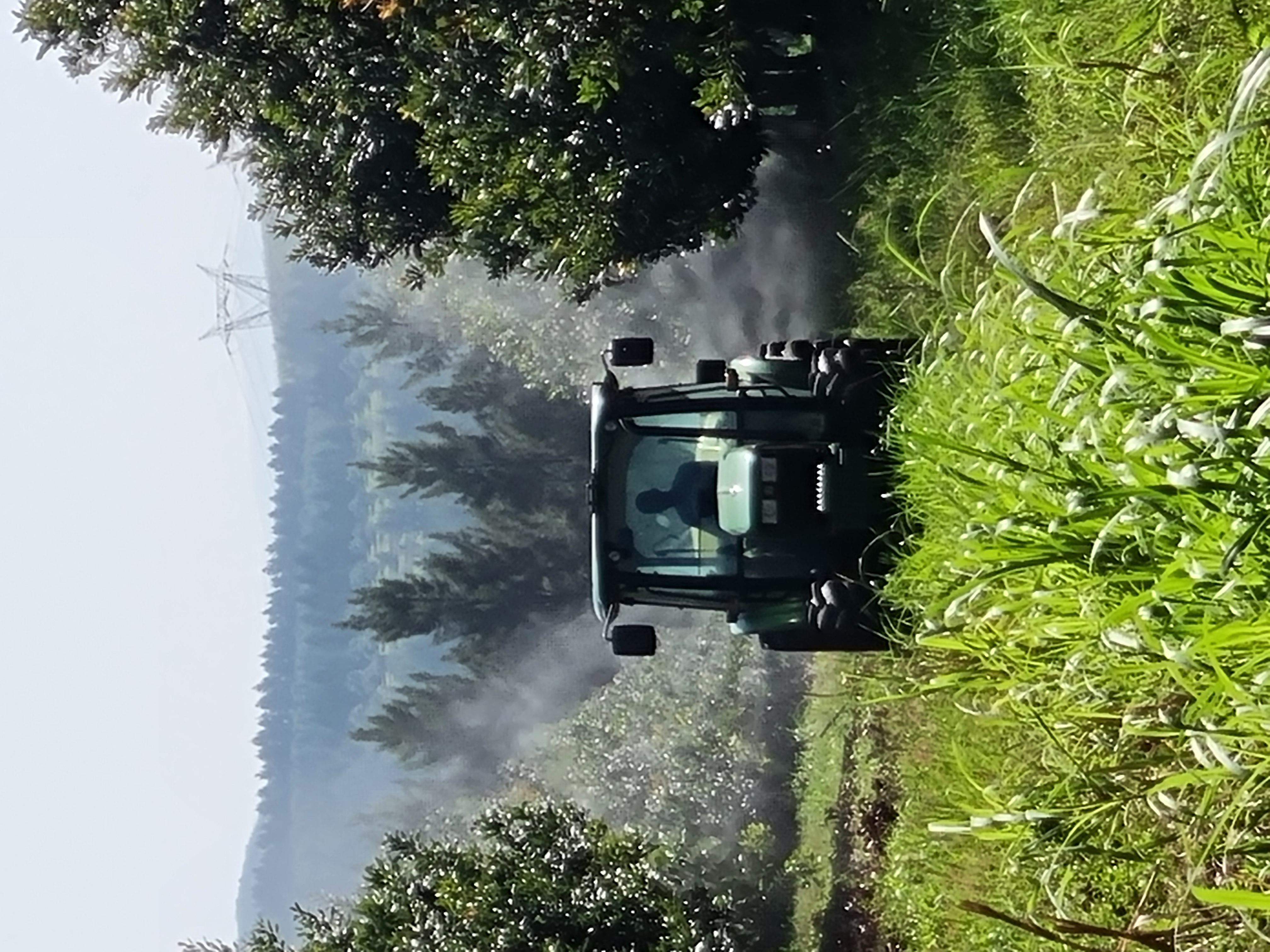 BlueFlé-equipped tractor spraying between orchard rows
